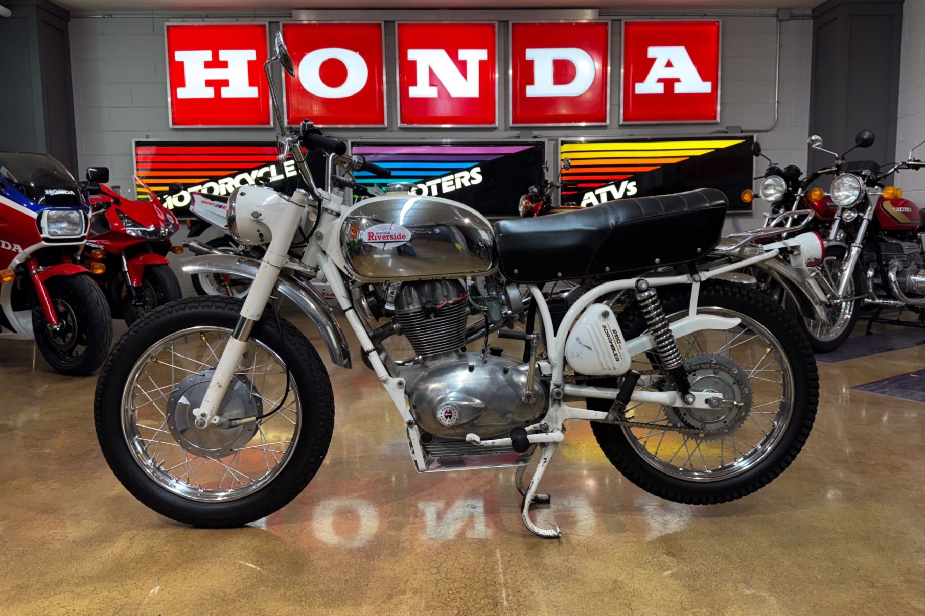 This 1968 Wards Riverside 250 is finished in white with polished chrome accents and stainless-steel fenders and is powered by a 247cc four-stroke single paired with a four-speed transmission. Equipment includes 18" wire-spoke wheels, a two-up seat, a rear rac…