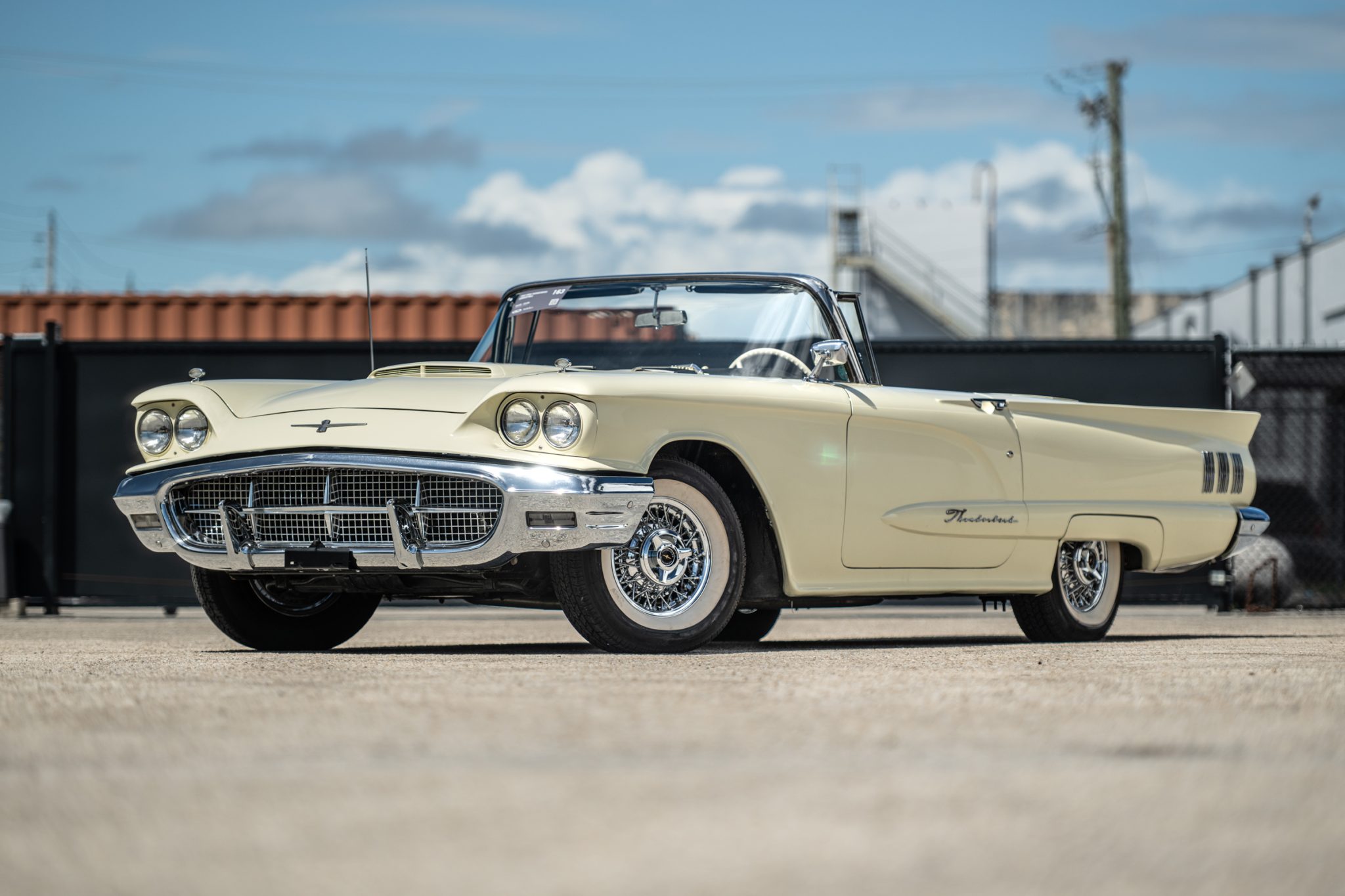 This 1960 Ford Thunderbird convertible is powered by a 352ci V8 paired a three-speed automatic transmission and is finished in Moroccan Ivory over black and white upholstery. Equipment includes a power-retractable black soft top, 14" wire-spoke wheels, drum b…