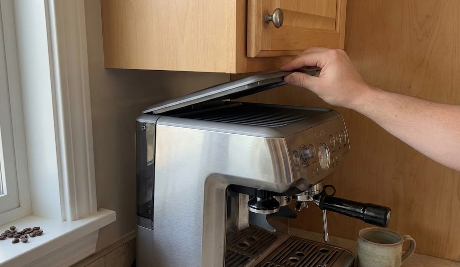 My coffee machine has always lived under an upper cabinet. It looks neat there and keeps the counter clear. The problem shows up every single time I need to open the lid to add water or coffee. The machine is heavy, the reservoir is full, and lifting it forwa…