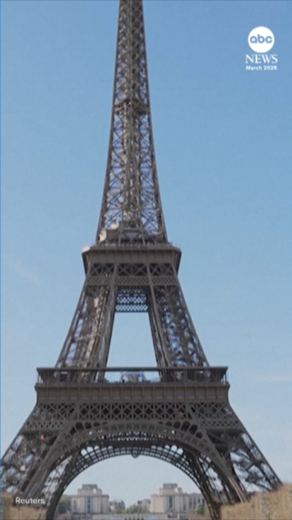 Daring visitors traversing a rope bridge suspended between two pillars of the Eiffel Tower some 200 feet above the ground.